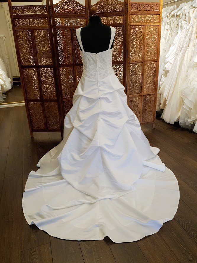 Klassisk smuk brudekjole i A-snit. Kjolens corsage har blonder og brede stropper. Skørtet er i satin og har balloneffekt.