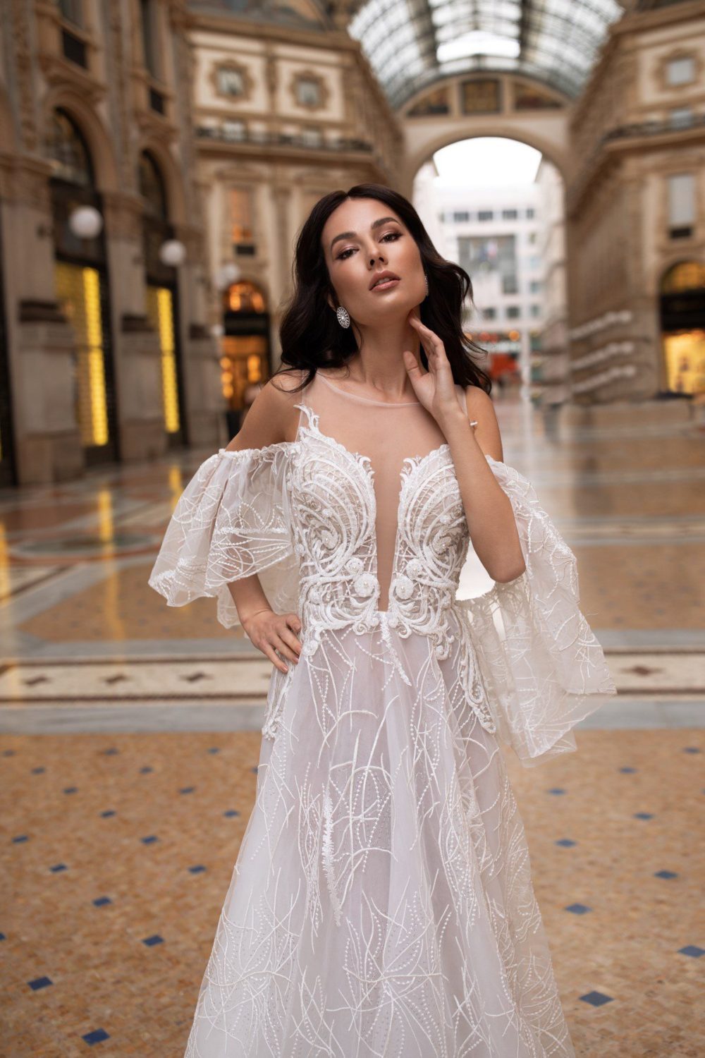 Pollardi Fashion Group. Ida Torez. Model Adriane. Let og dekorativ brudekjole i tyl med off-shoulder stropper og dyb udskæring foran.