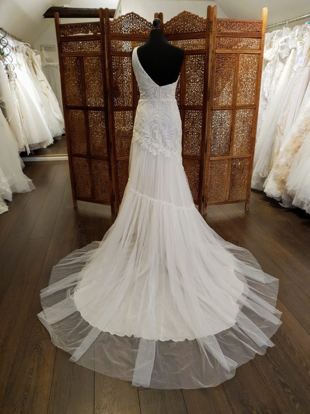 Pollardi Fashion Group. Asymmetrisk brudekjole med en enkelt bred skulderstrop og det smukkeste perlebroderi. Kjolens lette slanke skørt er i tyl.