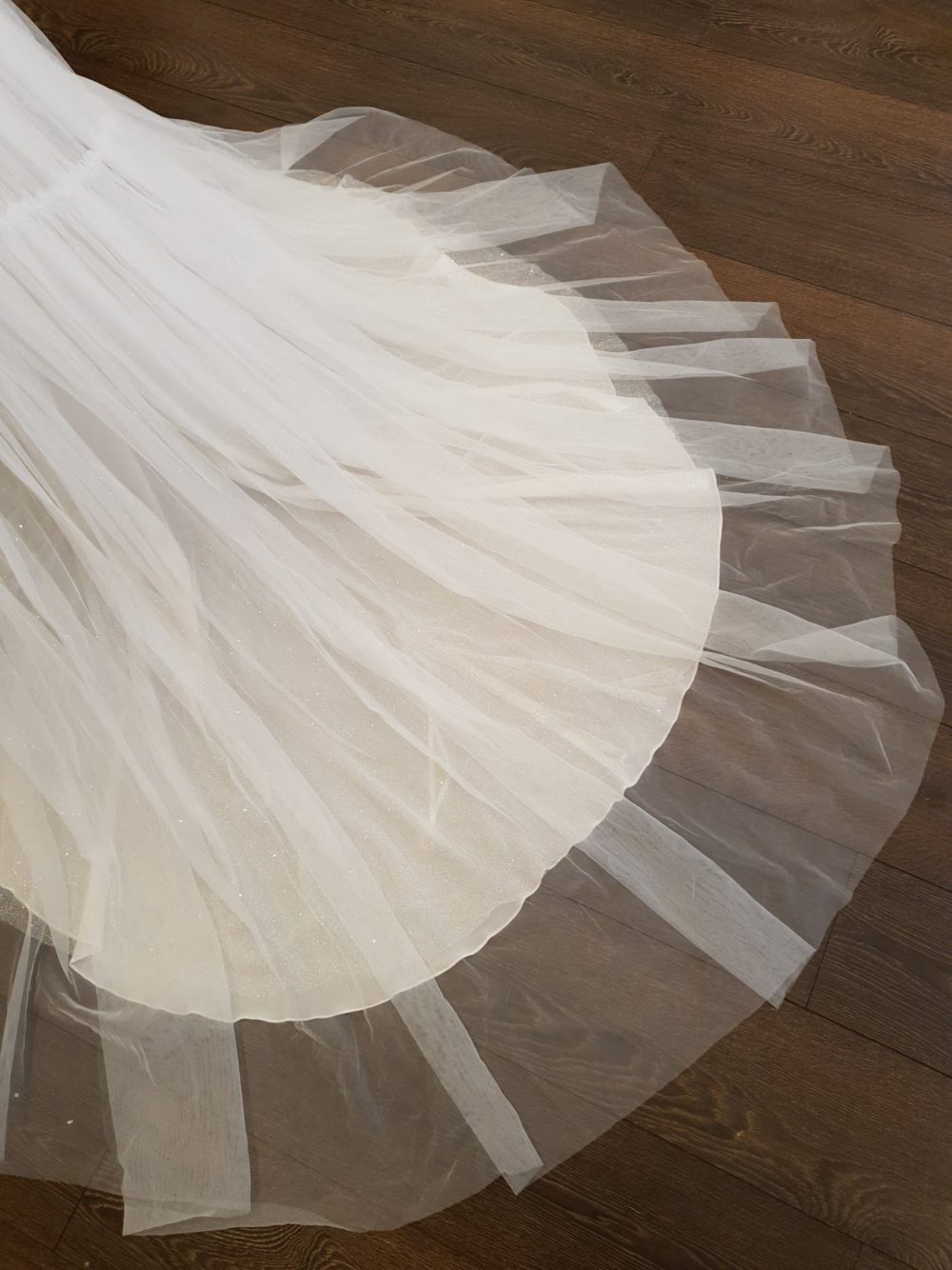 Pollardi Fashion Group. Asymmetrisk brudekjole med en enkelt bred skulderstrop og det smukkeste perlebroderi. Kjolens lette slanke skørt er i tyl.