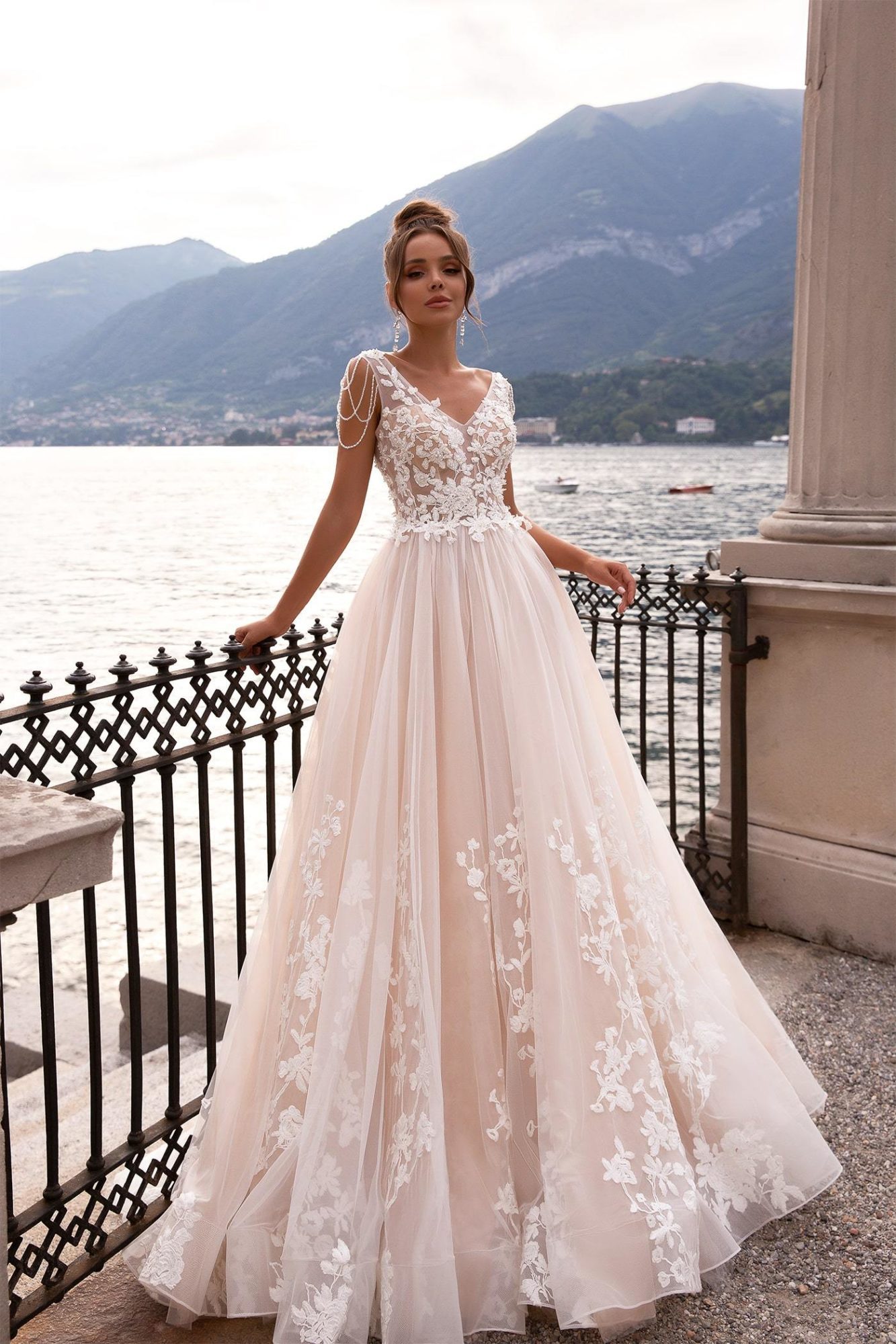 Maria Anette - Model 5022. A-line brudekjole med lys champagnefarve bund og smukke dekorative blonder i Ivory. Kjolen har v-udskæring både foran og bagpå og små perlekæde ud på skuldrene.