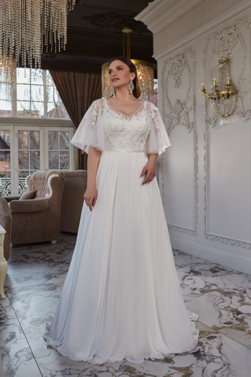 Gellena. Model Serafina PS2211. Denne skønne A-line brudekjole har smukke blonder på overkroppen, flagermusærmer der nemt kan fjernes, hvis det ønskes og et skørt i chiffon. På ryggen har den en dekorativ ryg, med knapper hele vejen op.