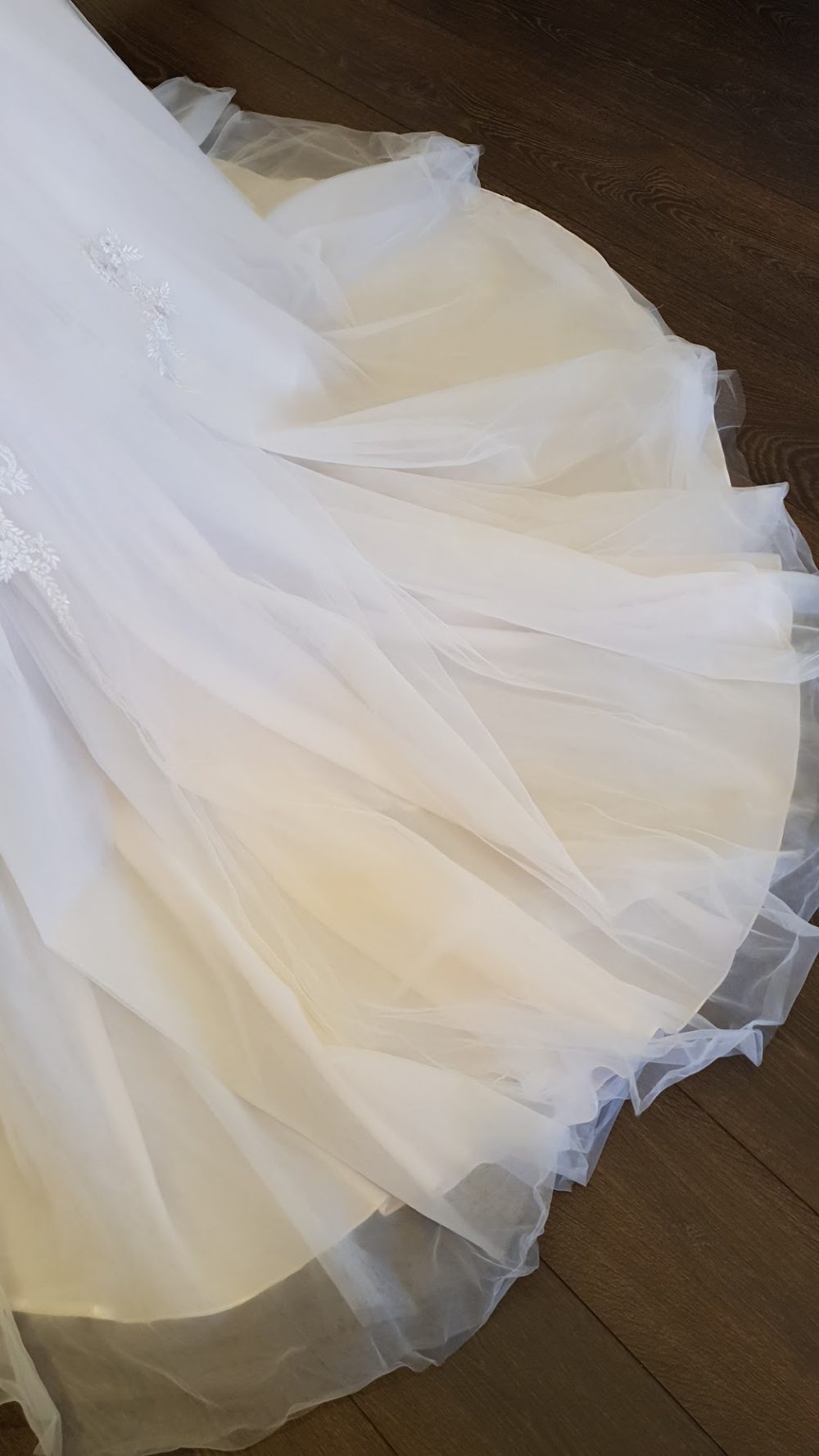 Virkelig smuk A-line brudekjole fra Pronovias. Kjolens blonder er dekoreret med smukke diskrete perler og lidt sølvtråd. Kjolen har v-udskæring både foran og bagpå og et tylskørt med nude farvet bund og med et smukt slæb.