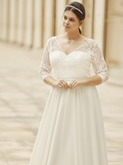 Let og skøn A-line brudekjole i chiffon fra Bianco Evento. Kjolen har v-udskæring både foran og bagpå, 3/4 lange ærmer og et lille slæb