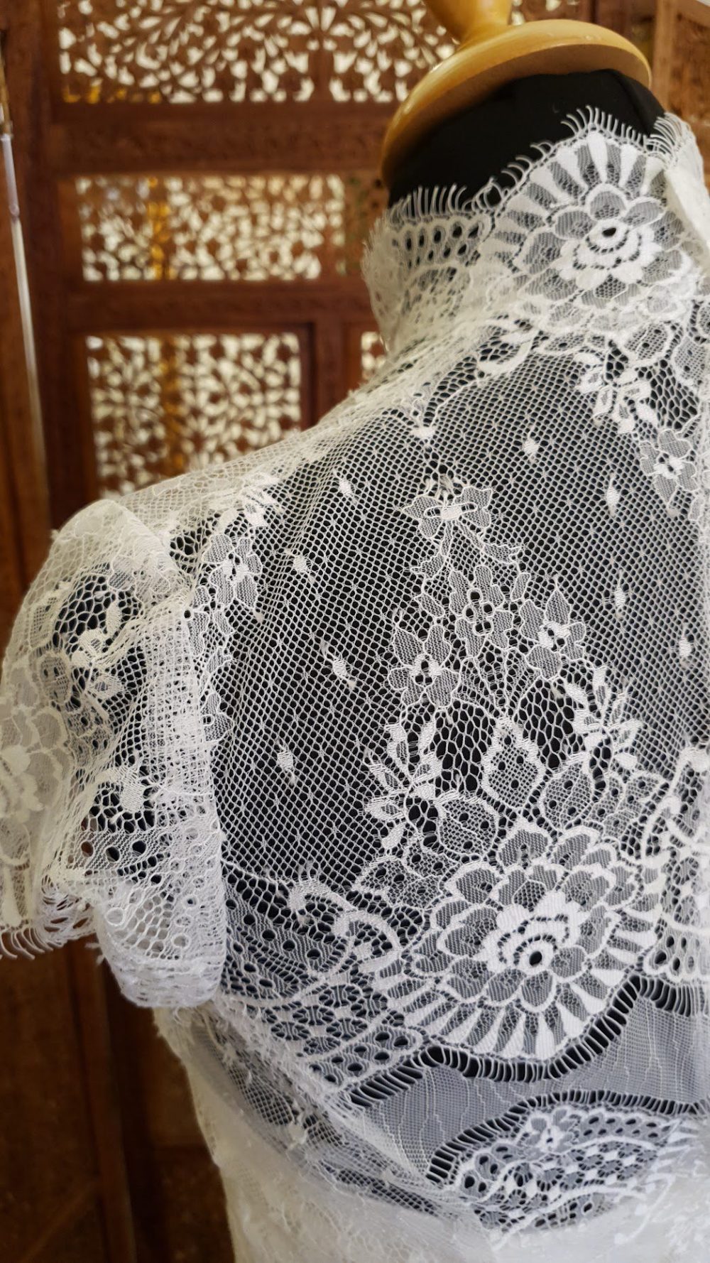 Fantastisk smuk brudekjole fra Rikke Gudnitz. Kjolen består af en inderkjole i satin og en ydre blondekjole med høj hals og små korte ærmer.