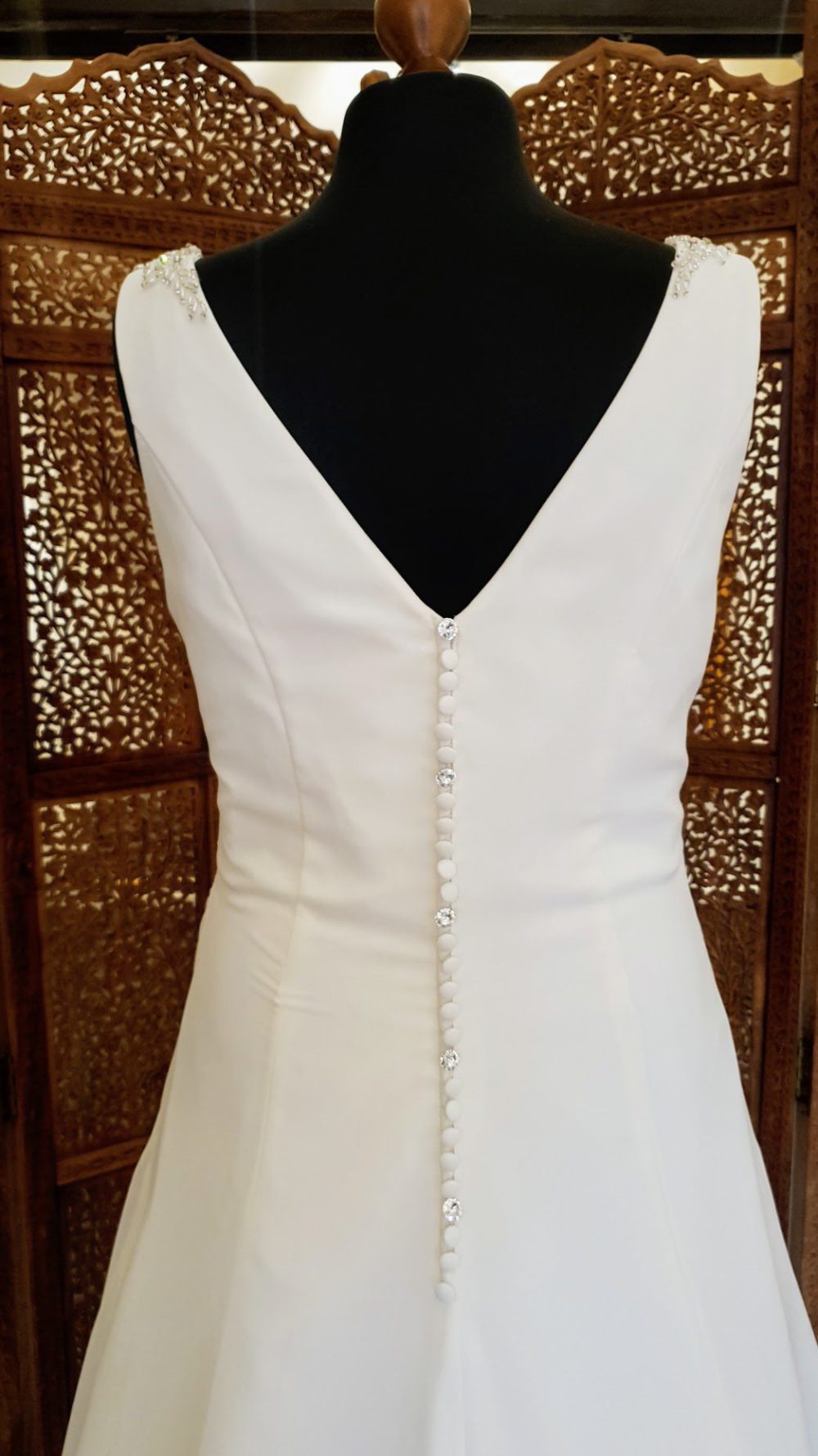 Special Day Bridal Wear. Model BB19519. Enkel og smuk draperet A-line brudekjole i chiffon med v-udskræring både foran og bagpå. Kjolen er dekoreret med smukke perler og rhinsten på skulderstropperne og har smukke knapper i ryggen.