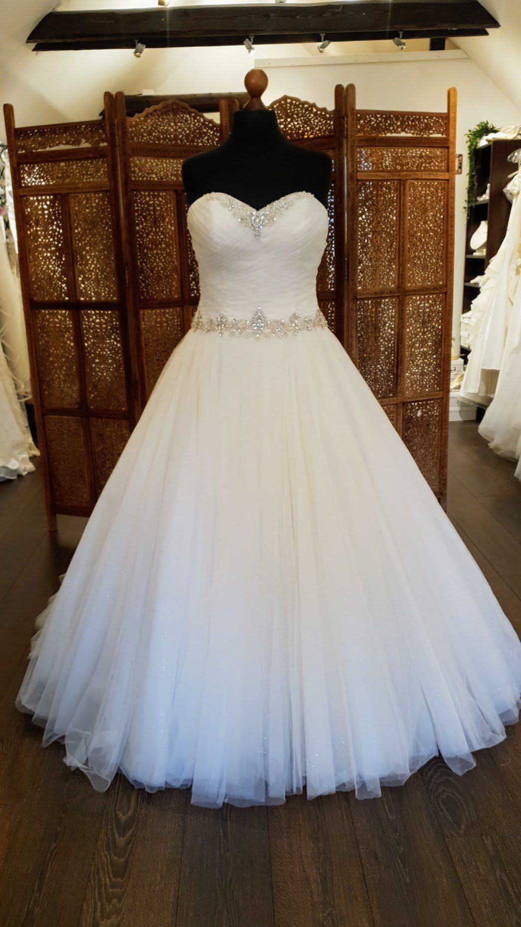 Prinsessekjole fra Special Day Bridal Wear. Model C18921. Corsagekjollen har smukke draperinger og er pyntet med rhinsten ved hjerteudskæringen og omkring taljen. Hele kjolen har glitter i sit tyl.