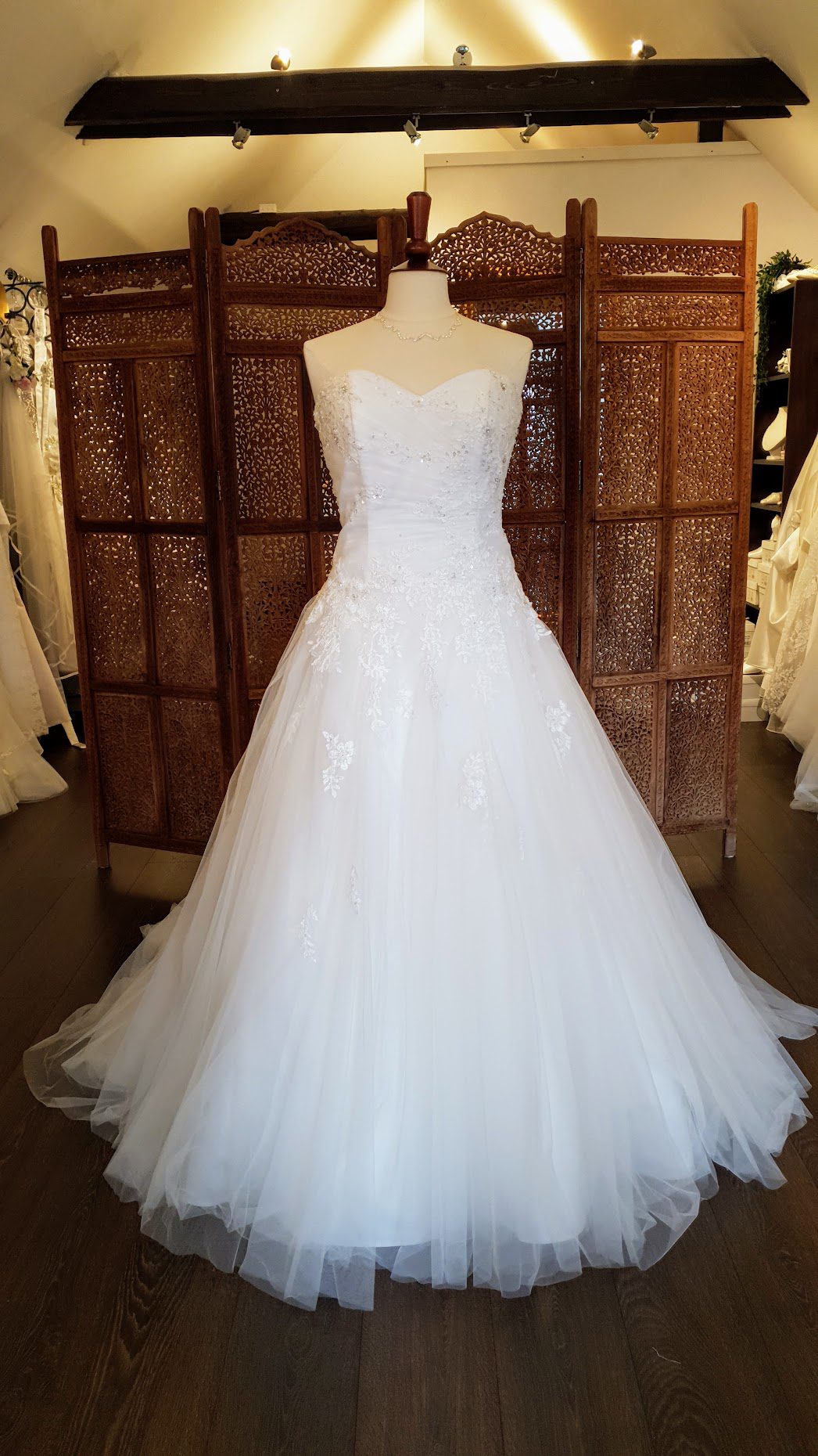 Smuk A-line brudekjole med tylskørt og blonder på corsagen der er pyntet med rhinsten, perler og pailetter. Kjolen har snøreryg og hjerteudskæring.