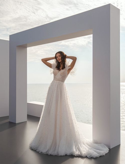 Perfioni Couture. Model Diana. Smuk og unik A-line brudekjole med et tylskørt fuld af perler. Overkroppen er designet i draperet tyl, har tylflæser på skuldrene og dyb v-udskæring på ryggen.