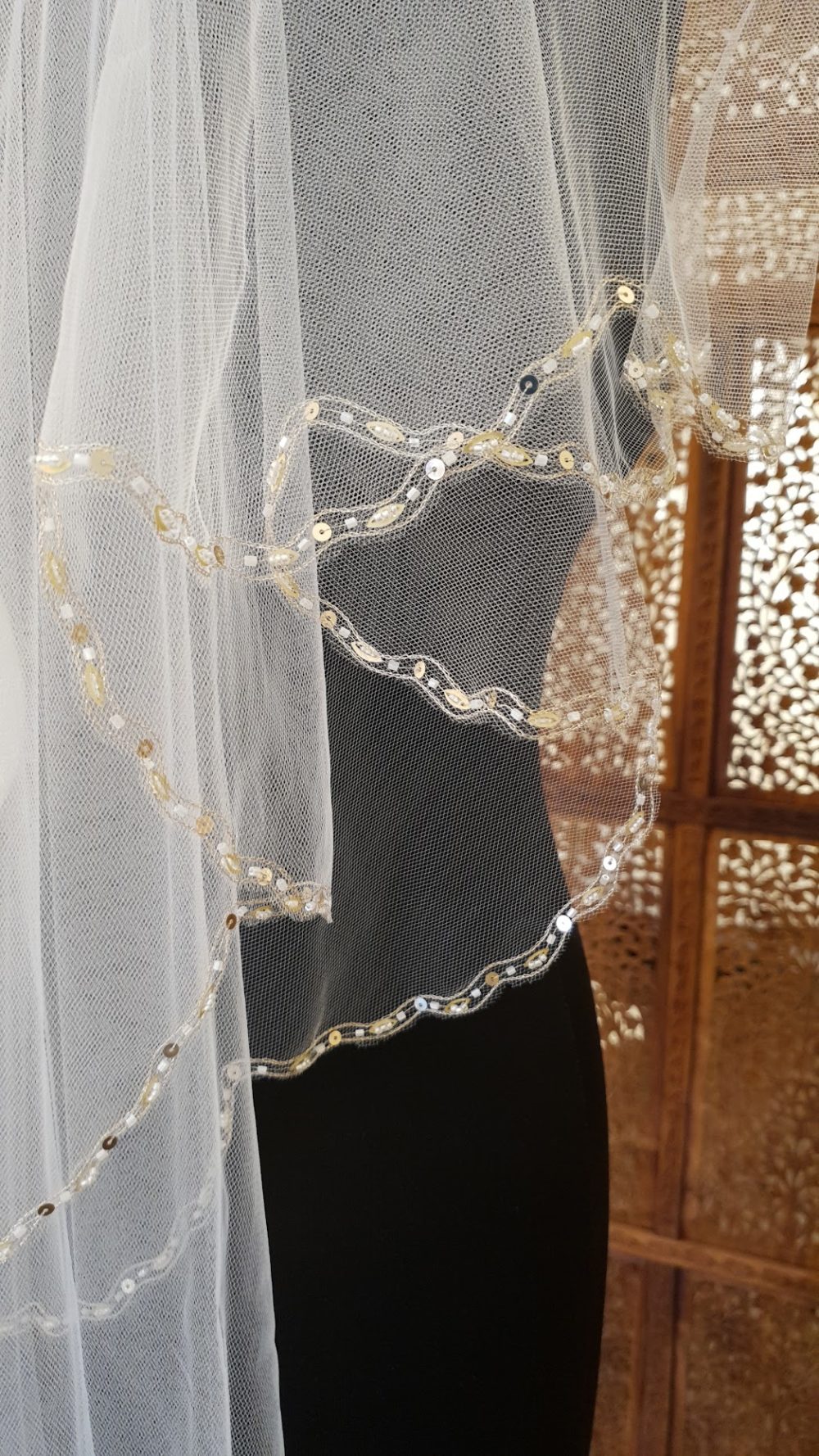 Dobbeltlaget slør med gylden tråd, perler og pailetter i kanten.