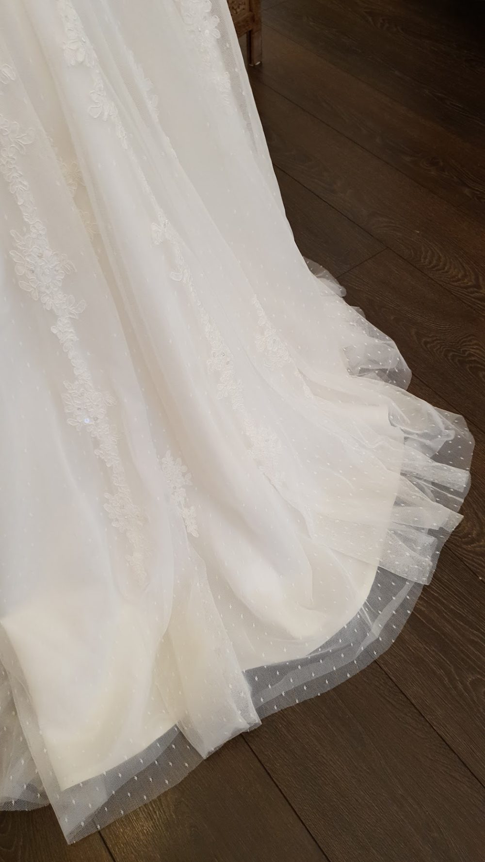 Smuk slank brudekjole fra Passions by Lilly med masser af blonder og prikket tylskørt. Kjolen har et draperet bånd og perler lige under barmen, snøreryg og næsten ingen slæb.