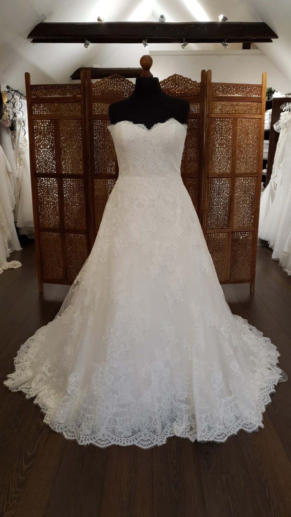 Smuk og romantisk A-line brudekjole med blonder fra top til tå. Kjolen er stropløs, har hjerteudskæring, snøreryg og et smukt langt slæb.