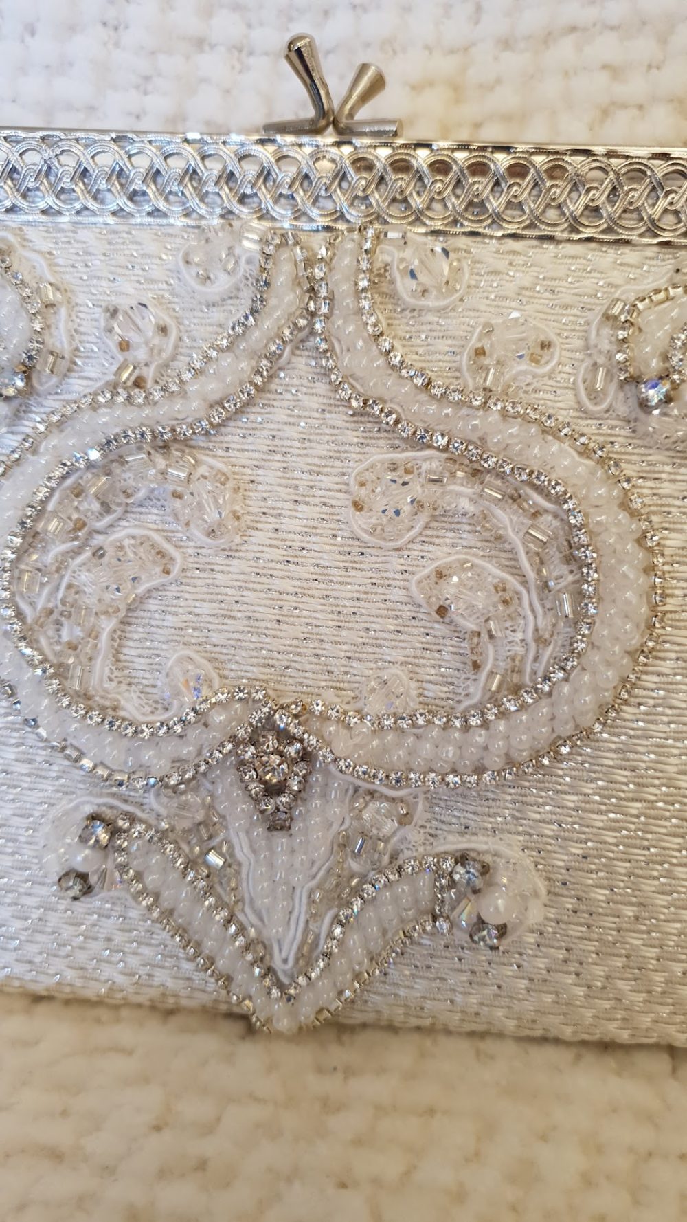 Smuk re-designet taske af Karina Bentzen i vintage stil. Tasken er Ivory med sølvtråd. Fronten er pyntet med blondeapplikationr og masser af perler og sten.