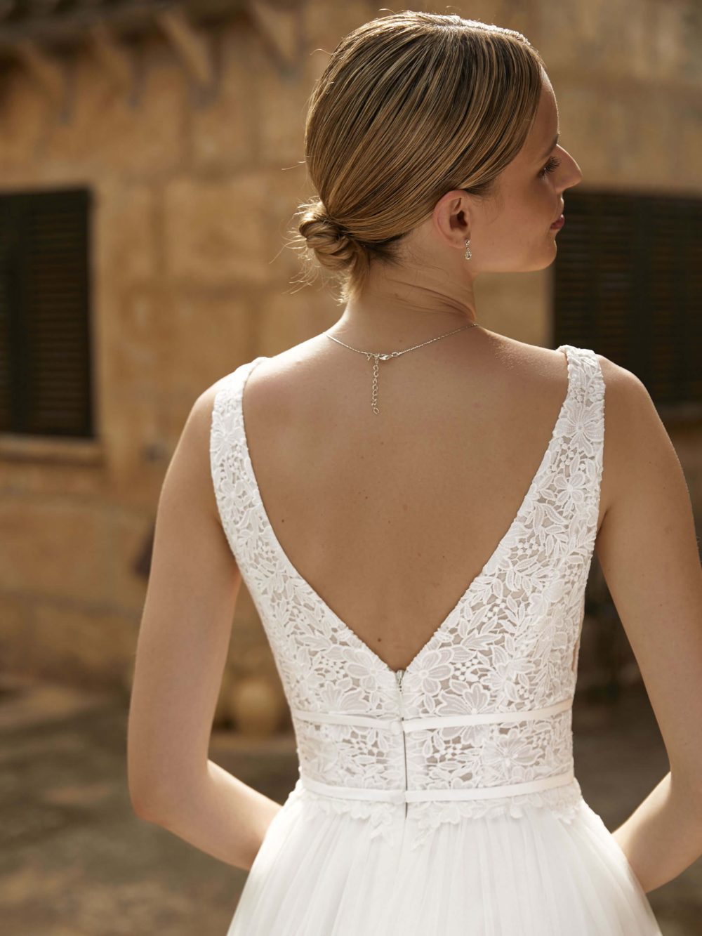 Bianco Evento. Model Keira. A-line brudekjole med tylskørt. Kjolen har blonder på overkroppen, V-udskæring både foran og bagpå og en smuk detalje med smalle bånd rund om taljen.