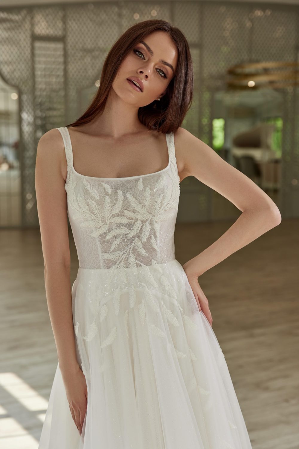 Gellena. Model Liberty. Smuk A-line brudekjole i tyl med firkantet udskæring, stropper og perlebroderi der fader ned på skørtet.