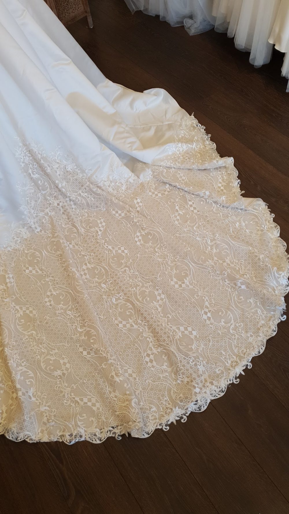Sottero and Midgley. Smuk og unik brudekjole i vintage-stil. Kjolen er i satin og har en kombination af farven Ivory og beige. Den har små ærmer, et skørt med et meget langt slæb og stofbetrukne knapper som en del af udsmykningen foran på kjolen.