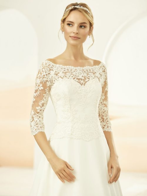 Bianco Evento. Model E-322. Bondebolero med bådudskæring, 3/4 ærmer og stofbetrukne knapper i ryggen,