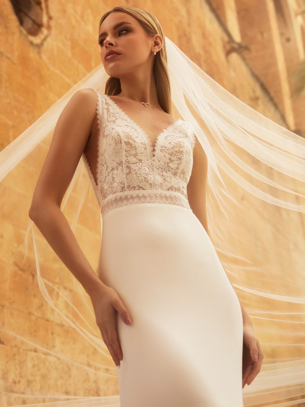 Model Ann Marie er en slank brudekjole med blonder på overkroppen og et skørt i chiffon. Kjolen har v-udskæring både foran og bagpå og brede stropper, samt et lille slæb.