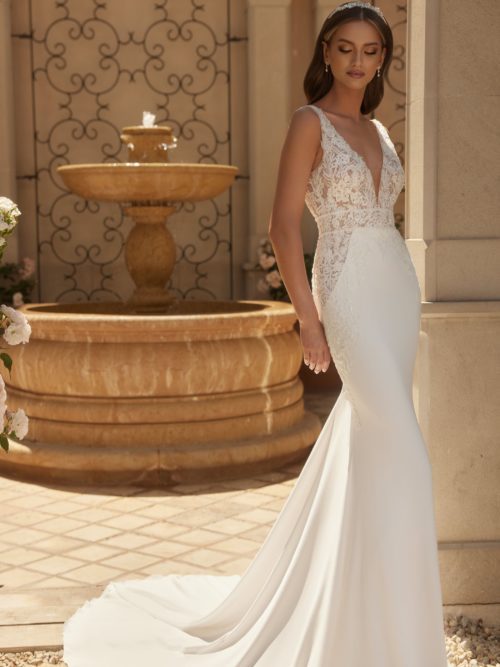 Bianco Evento. Limited Cellection. Model Citrine. En sensuel slank brudekjole i georgette og blonder. Kjolen har v-udskæring både foran og bagpå. brede stropper og transparente detalejr helt ned på siden af hofterne. Derudover har den et flot langt og enkelt slæb.