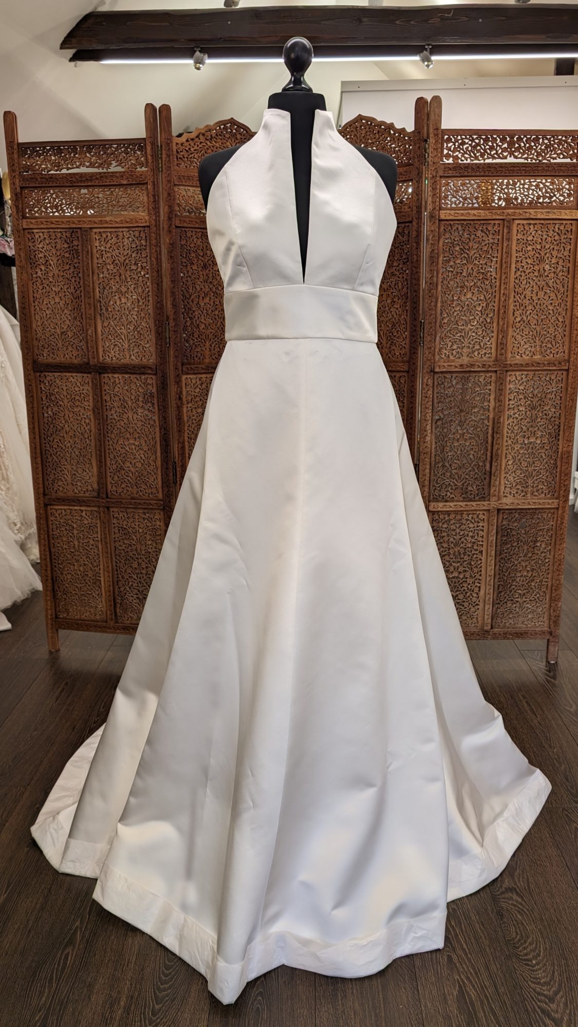 Jesus Peiro. Model 2359. A-line brudekjole i satin med halterneck. Kjolen har en smal dyb udskæring foran, en udskæring der danner krave og en helt åben og bar ryg. Derudover følger der et aftageligt tylskørt med til kjolen.