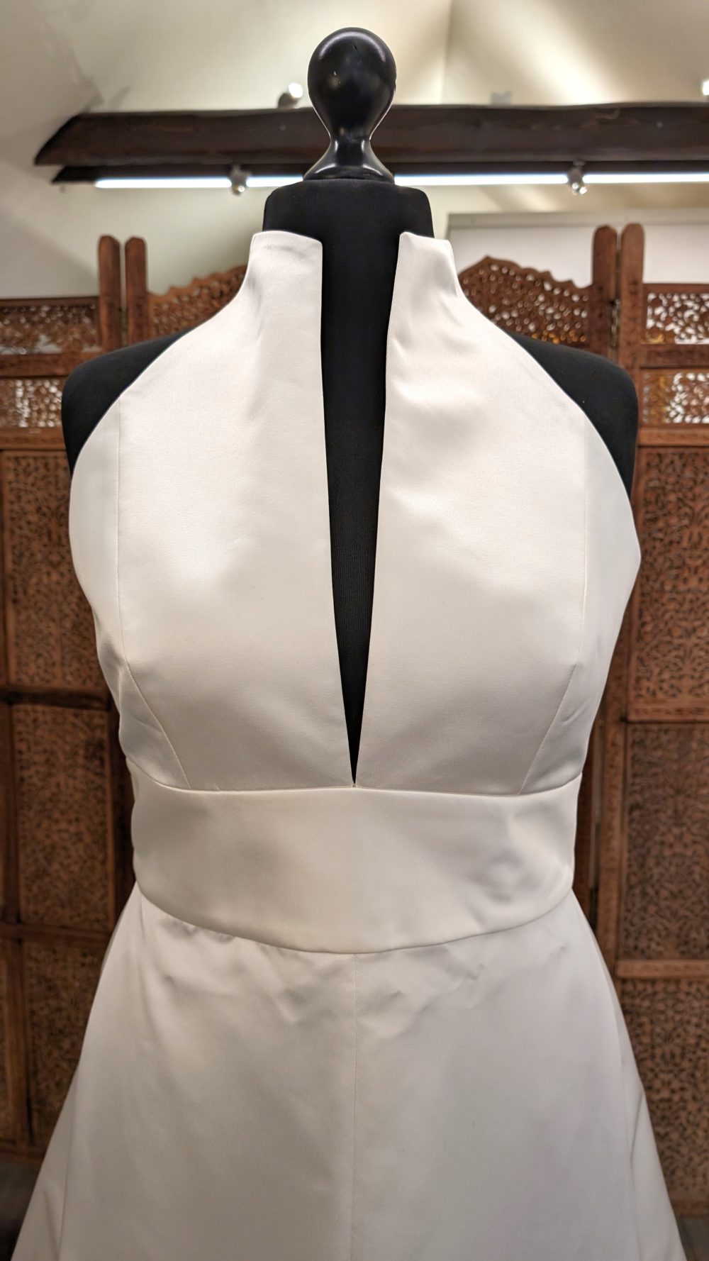 Jesus Peiro. Model 2359. A-line brudekjole i satin med halterneck. Kjolen har en smal dyb udskæring foran, en udskæring der danner krave og en helt åben og bar ryg. Derudover følger der et aftageligt tylskørt med til kjolen.