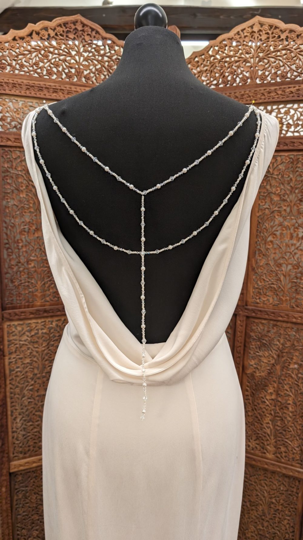 Karim design. Smuk og elegant silkekjole med høj lige halsudskæring foran og en dyb udskæring på ryggen med vandfaldseffekt.