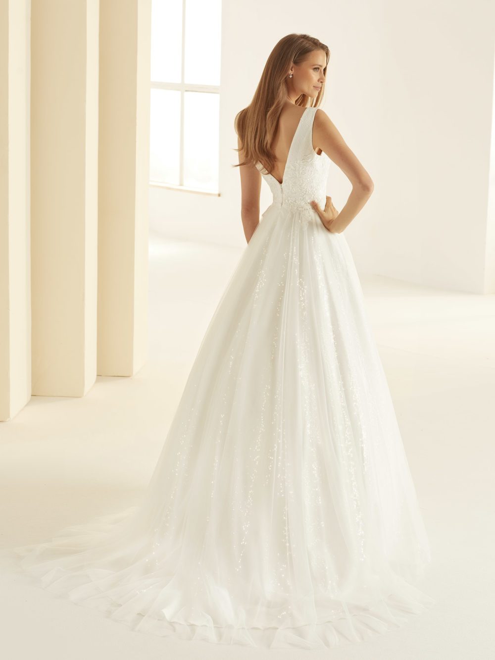 Bianco Evento . Model Larissa. Smuk A-line brudekjole med tylskørt. Kjolen har blonder på overkroppen, brede stropper og hjerteformet v-udskæring foran og en lidt dybere v-udskæring bagpå.