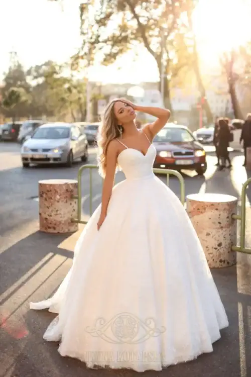 Iryna Kotapska. Model LV2111. Smuk A-line brudekjole med en meget enkel blondebroderi på hele kjolen. Kjolen har hjerteudskæring, spagettistropper og dyb rygudskæring.