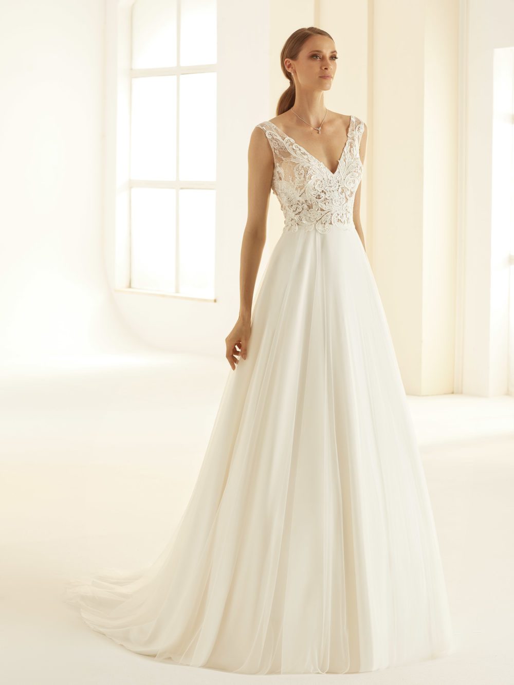 Bianco Evento. Model Preciosa. Smuk og let A-line brudekjole med tylskørt. Kjolen har blonder på overkroppen og v-udskæring både foran og bagpå.