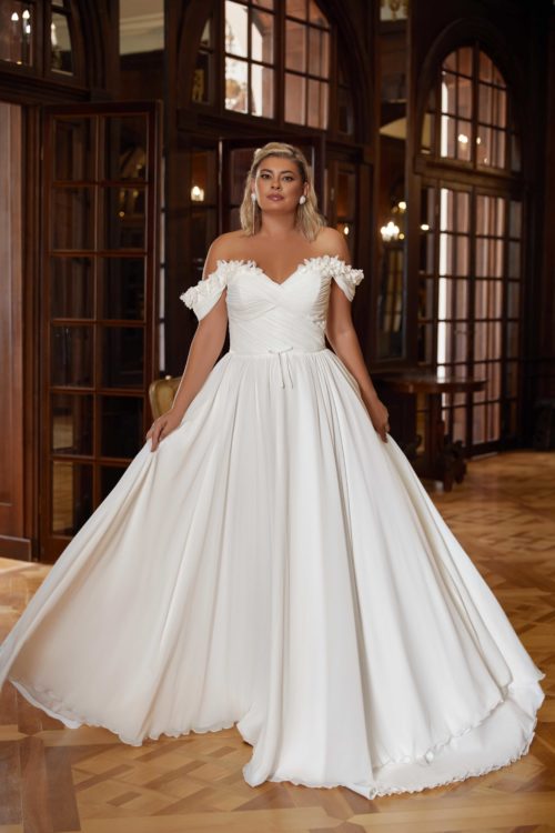 Kaya Nova. Model Sabah. Smuk og enkel A-line brudekjole i chiffon. Kjolen har drapperet overkrop, hjerteudskæring og ofshoulder stropper. Derudover har den smukke detaljer af små blomster, der dekorer hele udskæringen og forsætter ud på ærmerne.