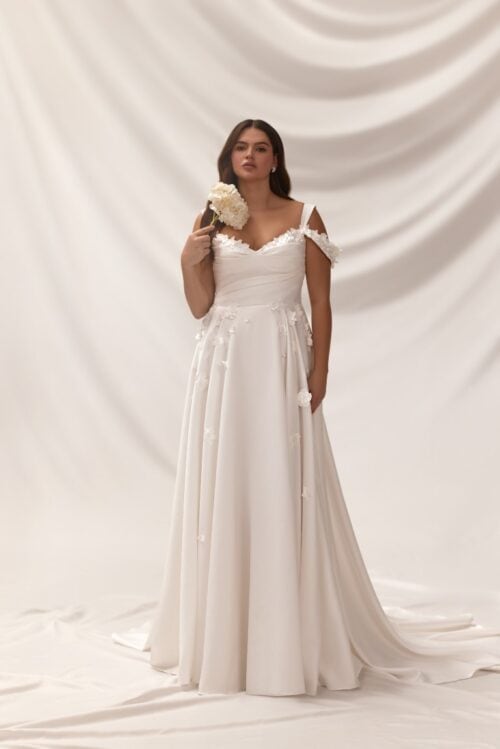 Melory. Model Noel. Smuk A-line brudekjole i Mikado satin med 3-D blomster elementer, off-shoulder stropper og lommer.