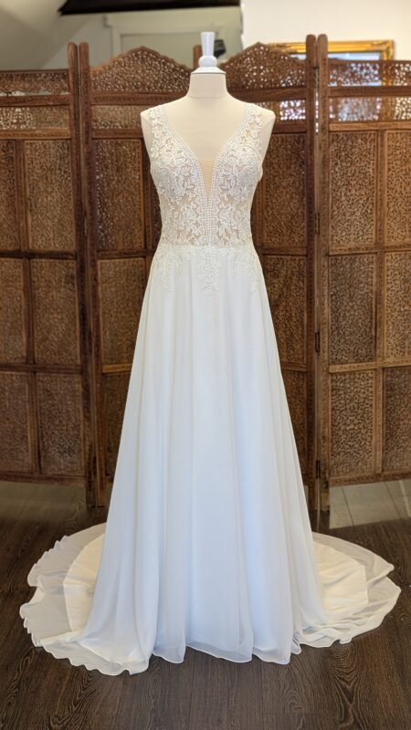 Say yes by Amelié. Model 40058. Smuk slank A-line brudekjole med chiffonskørt. Kjolen har transparente blonder på overkroppen, dyb kavalergang, brede stropper og lukket ryg med et lille key-hole.