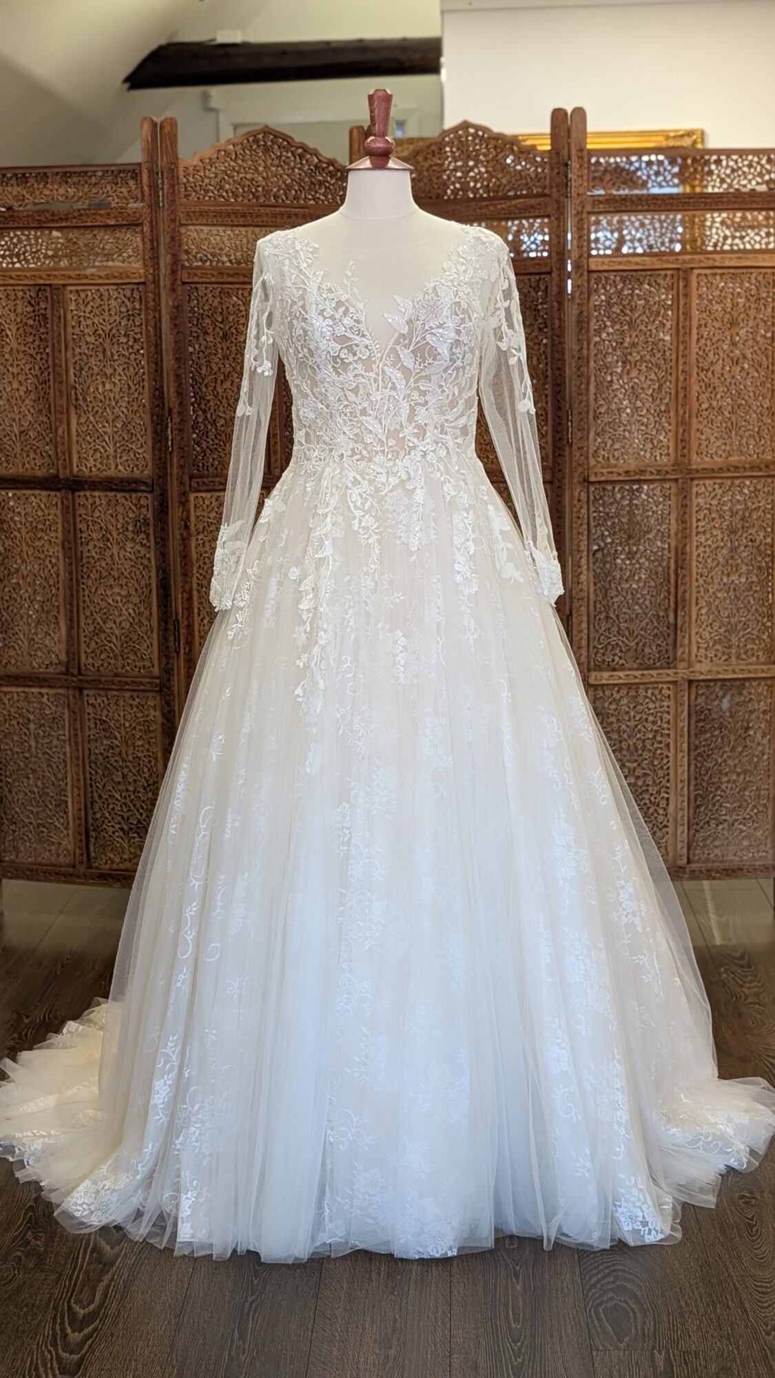 Tiffanys Bridal. Model Zurich. Smuk romantisk A-line brudekjole i tyl med blonder fra top til tå. Kjolen har transparent overkrop, lange ærmer i Ivory mesh og et stort key-hole på ryggen.