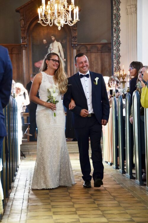 Beautiul by Enzoani. Model Bt-1829. Slank og smuk boho brudekjole med grafiske blonder fra top til tå. Kjolen har høj halsudskæring foran, et stort keyhole på ryggen. og et smukt langt slæb.