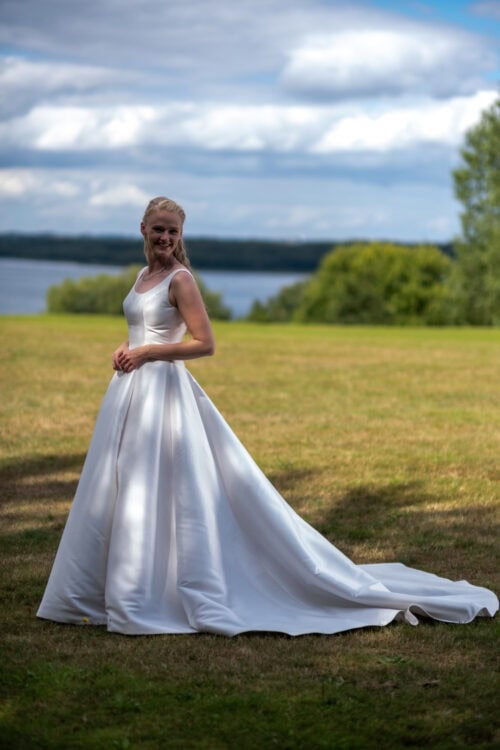 Modeca. Model Nanette. Enkel og minimalistisk A-line brudekjole i Mikado satin. Kjolen har rund udskæring foran, brede stropper og en dyb rygudskæring.