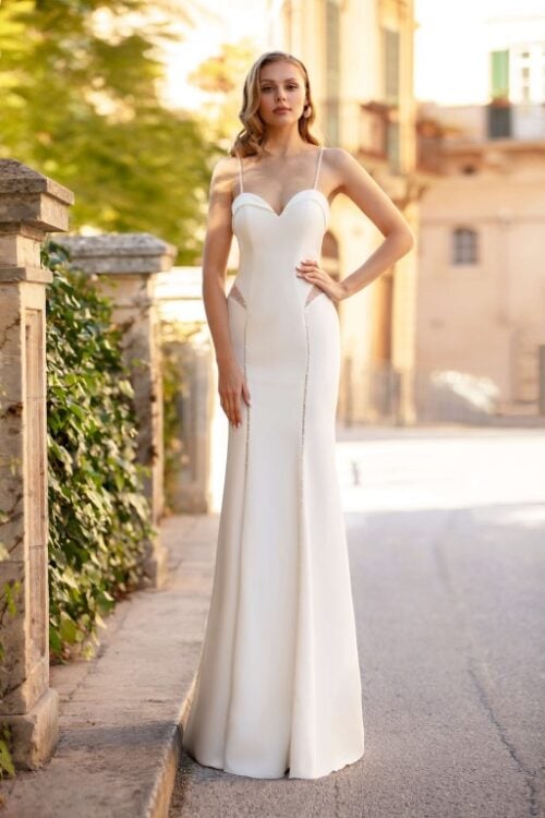 Jarice Bridal. Model Alcyna. Smuk, slank og sexet brudekjole i crepe med små cut-outs hvor der er nude mesh der er dekoreret med perler. Kjolen har hjerteudskæring og spagettistropper.