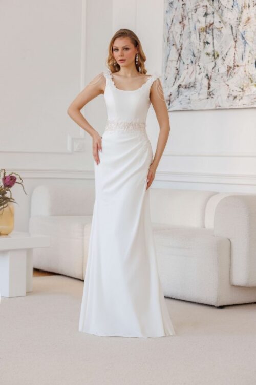 Jarice Bridal. Model Amirabel. Slank brudekjole i crepe, med blonder i taljen på nude bund, drapperet skørt og brede stropper der er dekoreret med blonder, 3-d blomster og perlekæder. Kjolen har rund udskæring foran og dyb rund udskæring på ryggen.