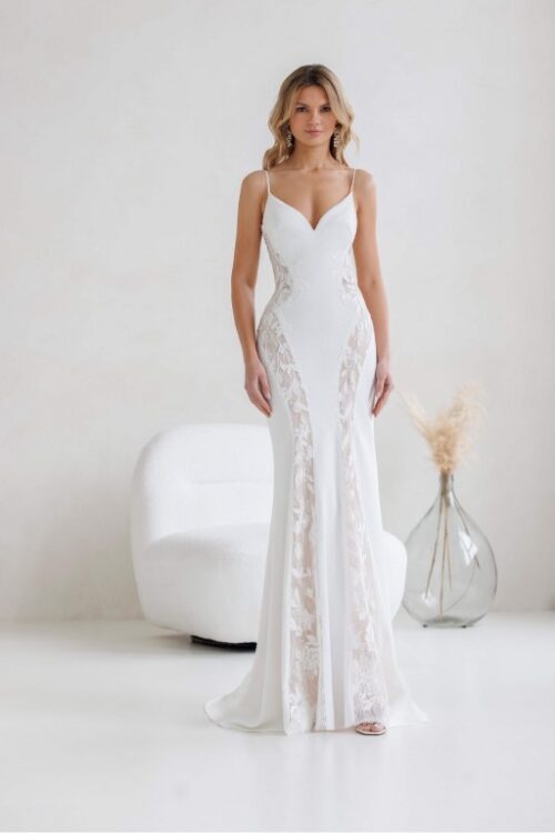 Jarice Bridal. Model Davos. Smuk slank brudekjole i crepe med lange nude linjer med smukke blonder. Kjolen har v-udskæring, spagettistropper og en dyb v-udskæring på ryggen.