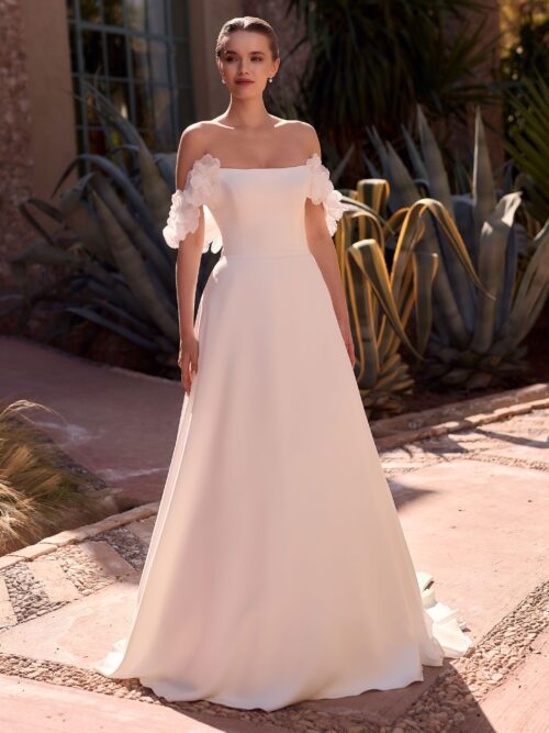 Bianco Evento. Model Betsi. A-line brudekjole i crepe med bådudskæring, off-shoulder stropper der er dekoreret med store smukke 3-D blomster.