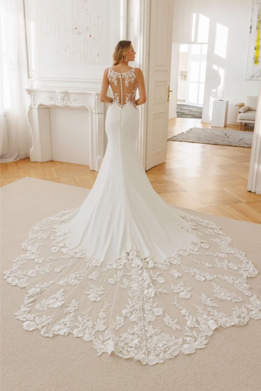 Jarice Bridal. Model Alvina. Smuk slank brudekjole i crepe med cut-outs i siderne på taljen, som har nude mesh og blonder. Kjolen har en lukket men dekorativ transparent ryg i nude mesh med blonder og et helt ekstraordinert smukt slæb.