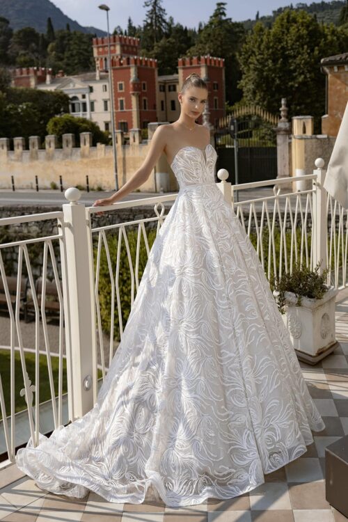 Bella by Eglantine. Model BEL22435. Meget smuk stropløs A-line brudekjole i tyl. Kjolen har en meget smuk vævning som træder tydeligt frem pga. den sarte rosa undertone i kjolen. Kjolen har hjerteudskæring, knapper i ryggen og et langt flot slæb.