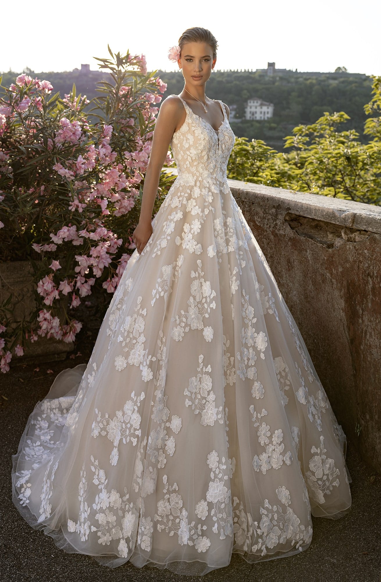 Bella by Eglantine. Model BEL22425. Smuk romantisk A-line brudekjole med blonder fra top til tå. Kjolen har brede stropper og dyb ryg. Bundfarven er nude, hvilket fremhæver de smukke Ivory blonder.
