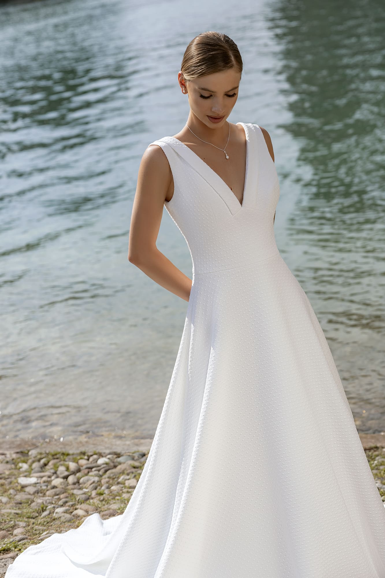 Belle by Eglantine. Model BEL22437. A-line brudekjole i jarquard stof med små tern. Kjolen har brede stropper, v-udskæring både foran og bage, samt en lille krave i halsudskæringen.
