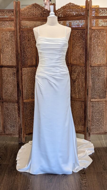 Pronovias. Model Betta. Smuk og elegant enkel tætsiddende brudekjole i satin. Kjolen har draperet krop, lige skæring over barmen og spagettistropper.