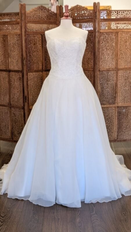 White One. Model Sidney. Klassisk A-line brudekjole med hjerteudskåret corsage med blonder og et let men fyldigt tylskørt. Kolen har dyb rygudskæring og en smule drop waist line foran.