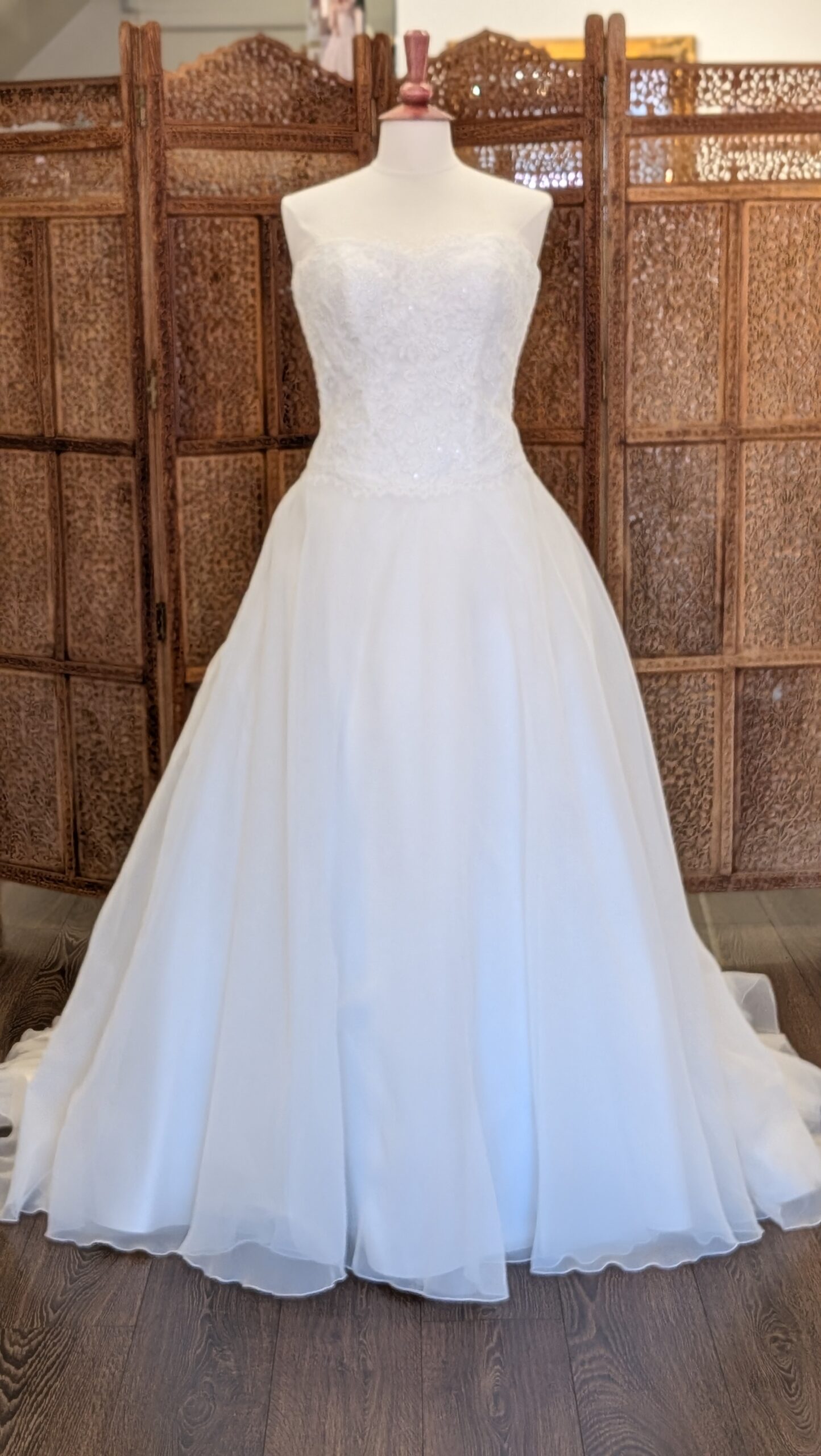White One. Model Sidney. Klassisk A-line brudekjole med hjerteudskåret corsage med blonder og et let men fyldigt tylskørt. Kolen har dyb rygudskæring og en smule drop waist line foran.