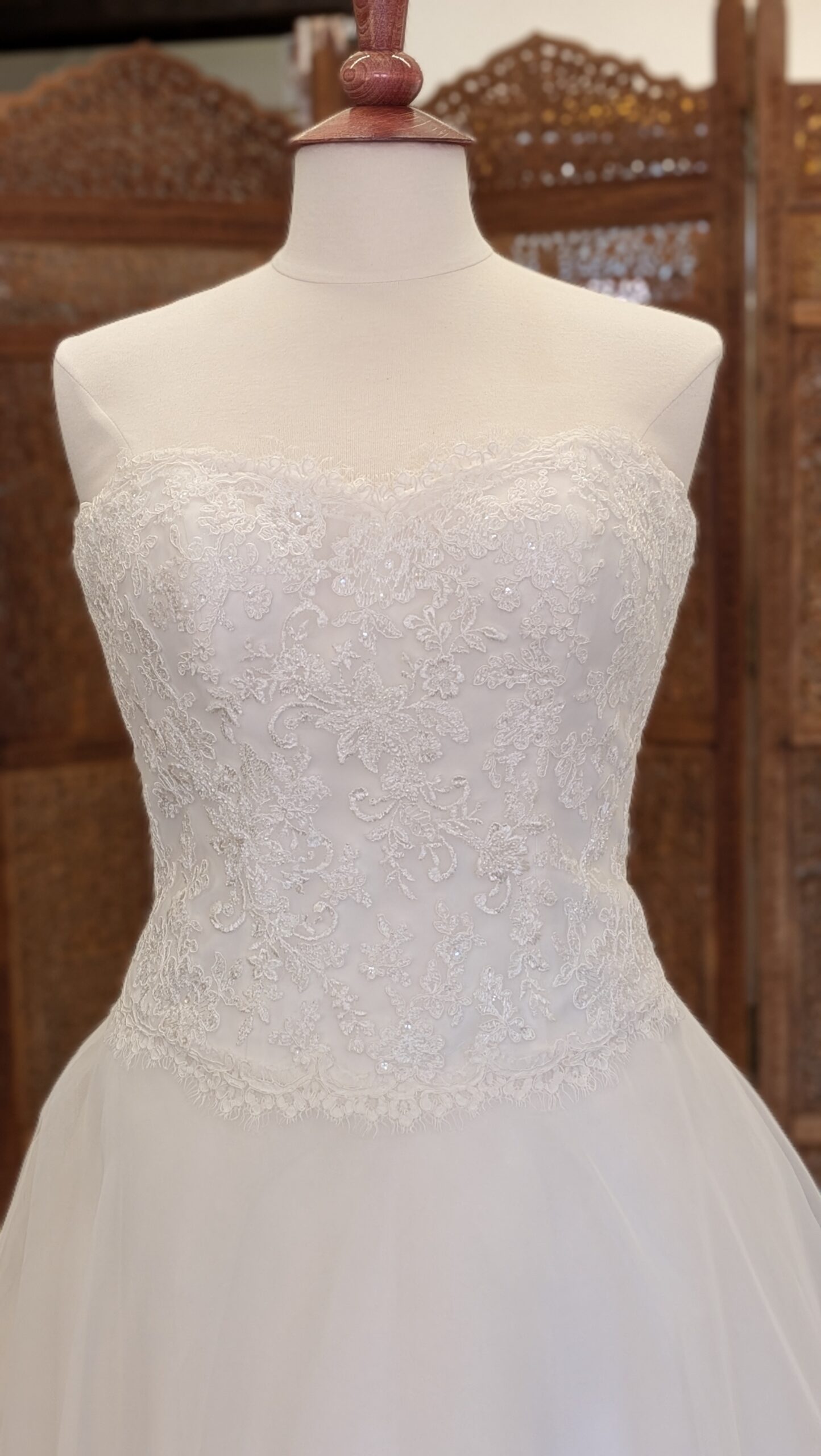 White One. Model Sidney. Klassisk A-line brudekjole med hjerteudskåret corsage med blonder og et let men fyldigt tylskørt. Kolen har dyb rygudskæring og en smule drop waist line foran.