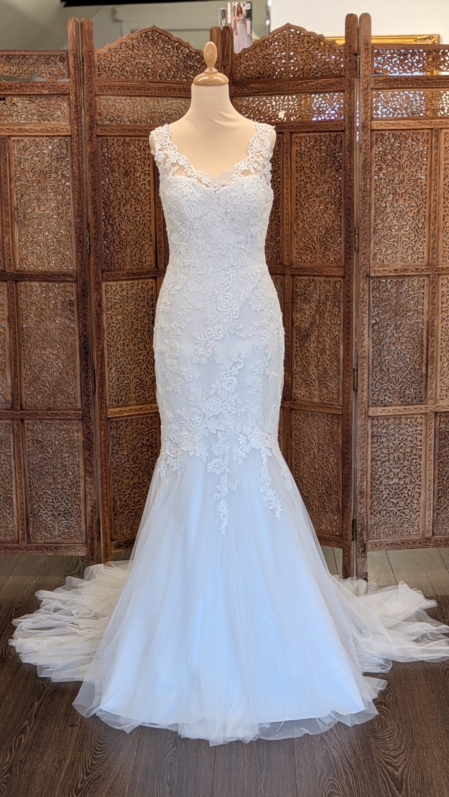 White One. Model Billie. Smuk slank blondekjole med brede stropper og smukke blonder der dækker over en hjerteudskåret corsage og danner v-udskæring både foran og bagpå. Blonderne fader ud omkring knæene, hvor kjolens skørt går over i et let tylskørt med et lille slæb.
