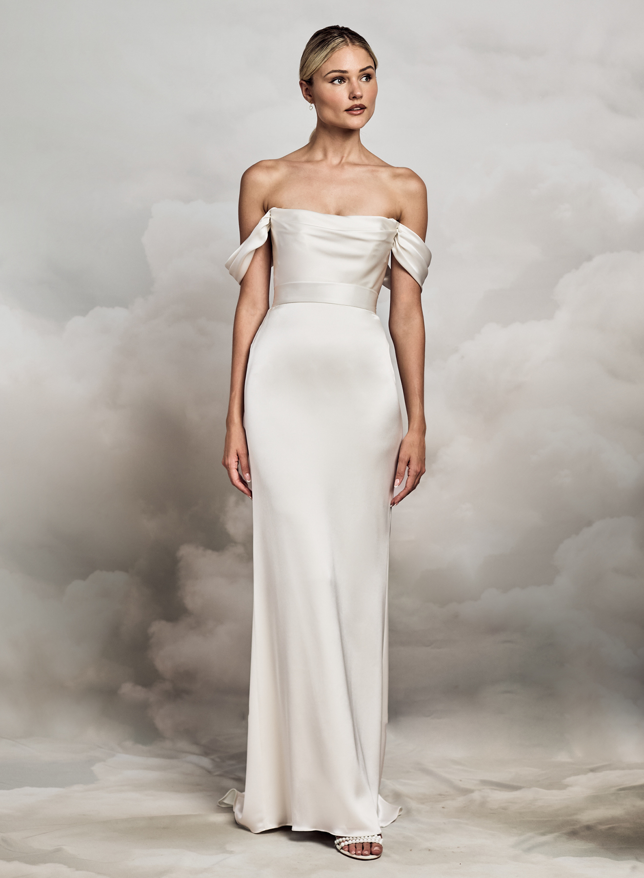 Catherine Deane. Model Dune bodies satin. Smuk og enkel corsage med draperet lige skæring hen over barmen. Off-shoulder stropperne er aftagelige. Lynlås i ryggen.