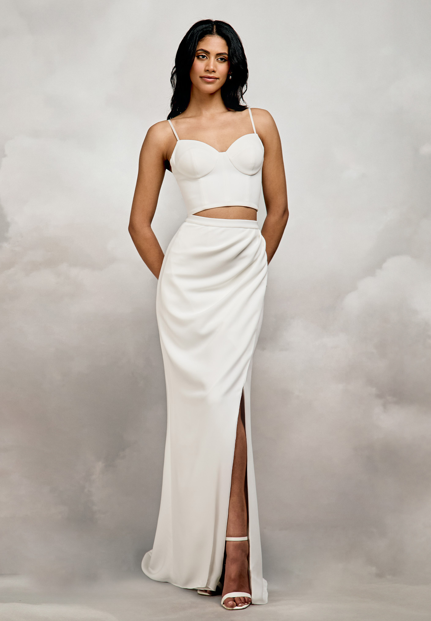 Catherine Deane. Model Esmarieskirt. Elegant slankt skørt i crepe med 2,5 cm bred linning i taljen. Skørtet har desuden en høj slids og draperet front, der giver bliver linjer omkring mave og hofter. Lille slæb,